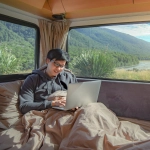 Man working from the bed in his RV