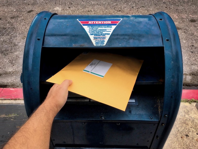 putting an envelope in a mailbox