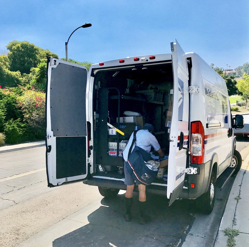 USPS Driver carregando correio para o caminhão