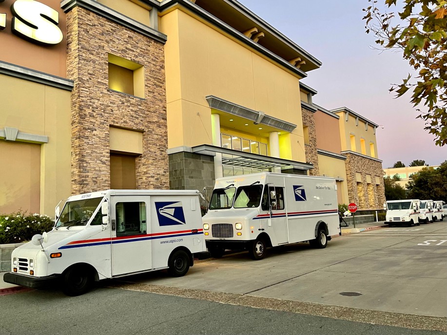 usps trucks parked outside a store