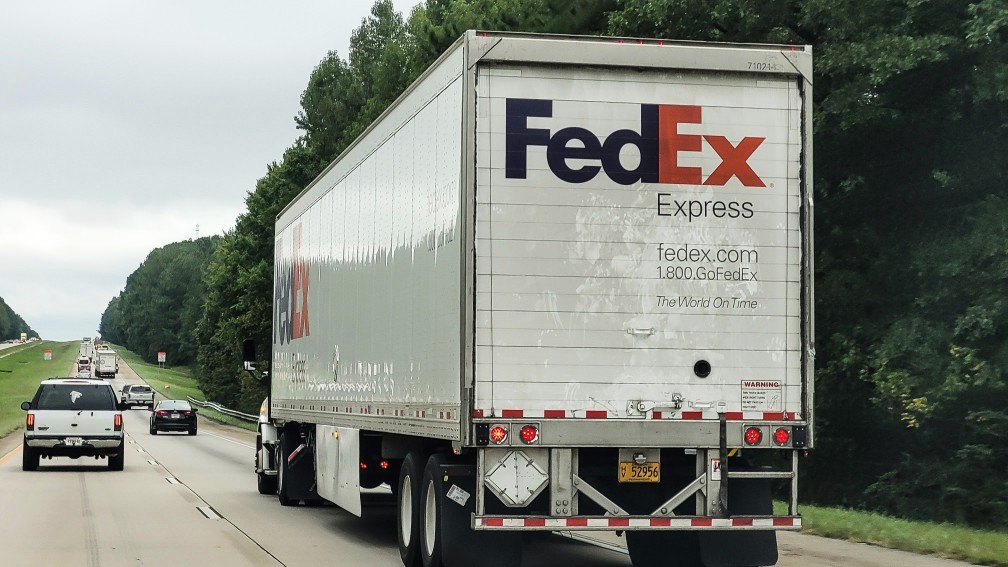 fedex truck driving on a road