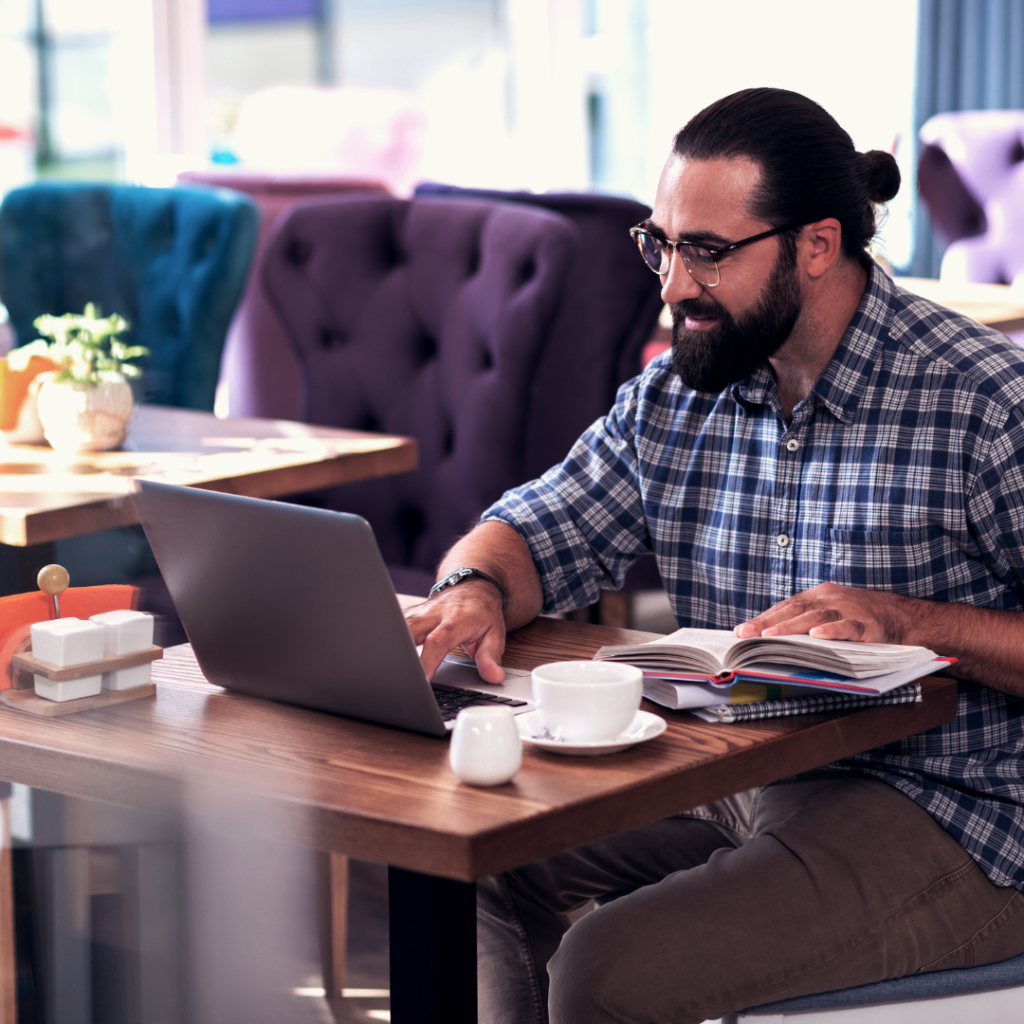 man teaching english from his couch with a laptop and headphones