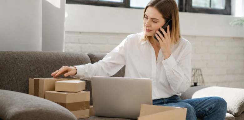 Woman managing package shipments and virtual mailbox forwarding from home on her laptop and phone