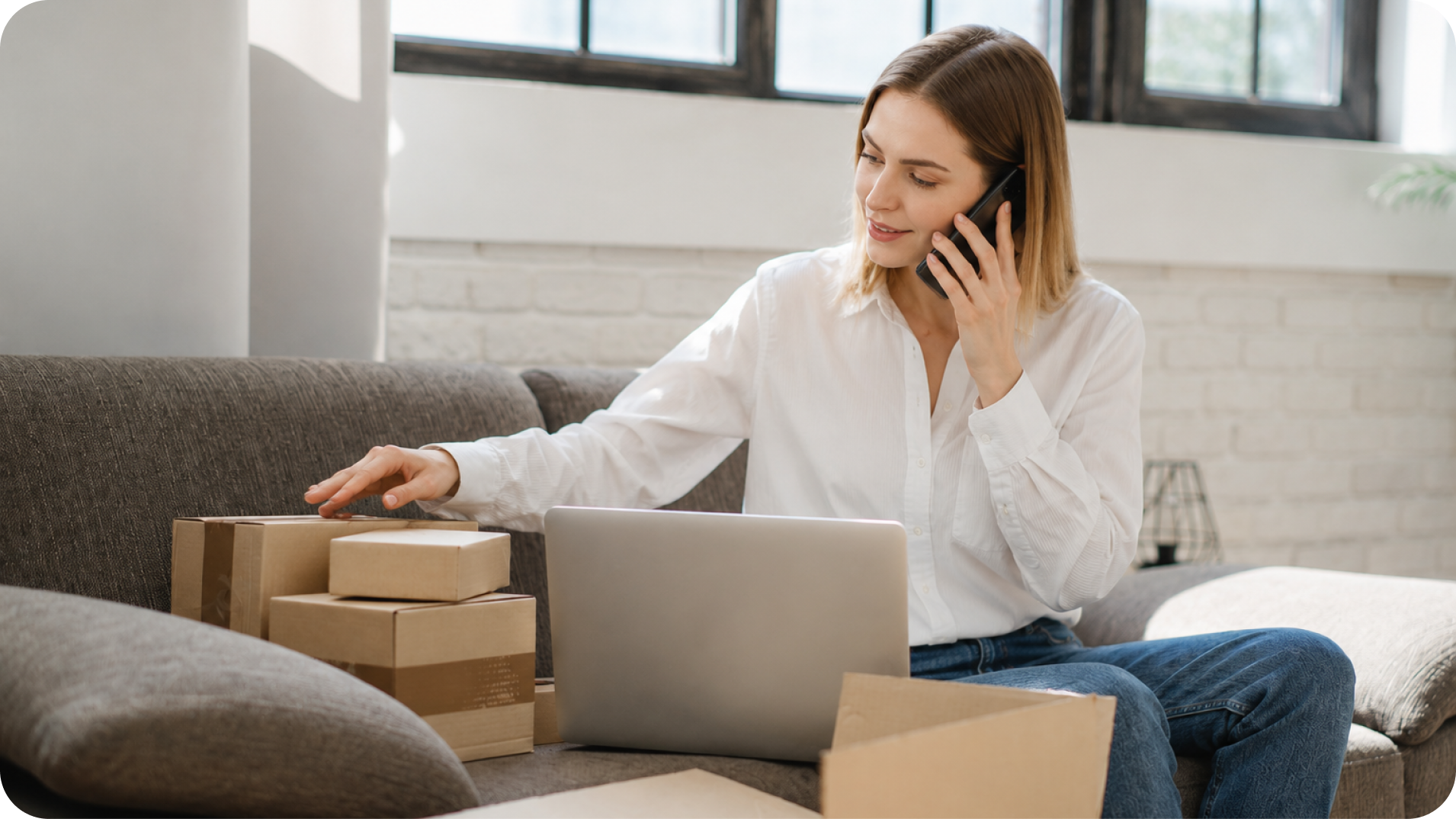 Woman managing package shipments and virtual mailbox forwarding from home on her laptop and phone
