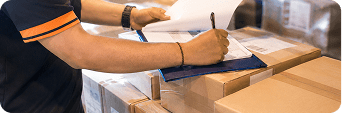 Close-up of hands opening a white envelope at a desk.